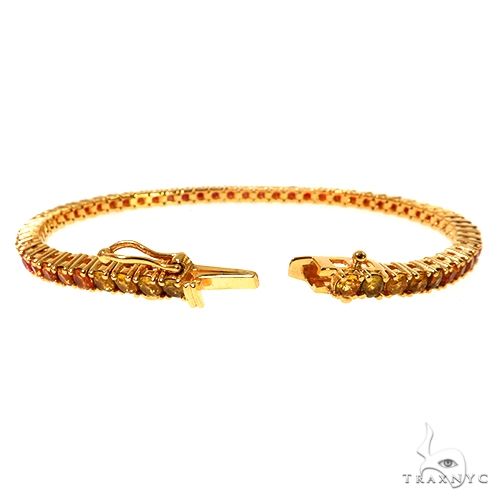 Yellow gold tennis bracelet with deep red fire sapphire gemstones, elegant and refined