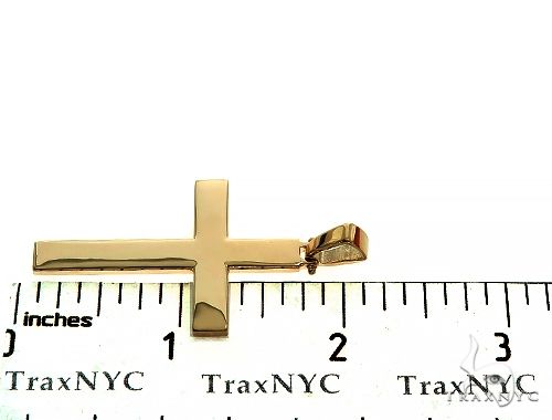 14K yellow gold solid men's cross pendant with polished finish, shown next to ruler for size