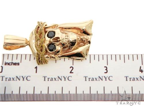14K rose gold skull pendant with diamond crown and black gemstone eyes, 1.5 inches long