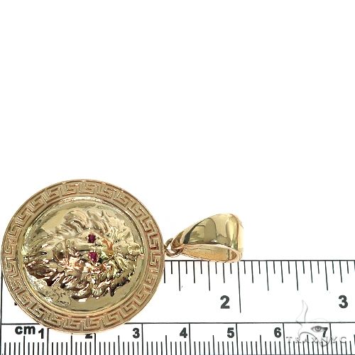 14K yellow gold lion pendant with ruby eyes and detailed mane, measures about 3 cm wide