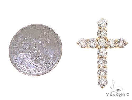 14k yellow gold cross pendant with round diamonds, shown next to a quarter for size reference