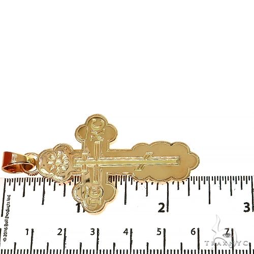 18K yellow gold cross pendant with intricate detailing and 2.5-inch length displayed on ruler
