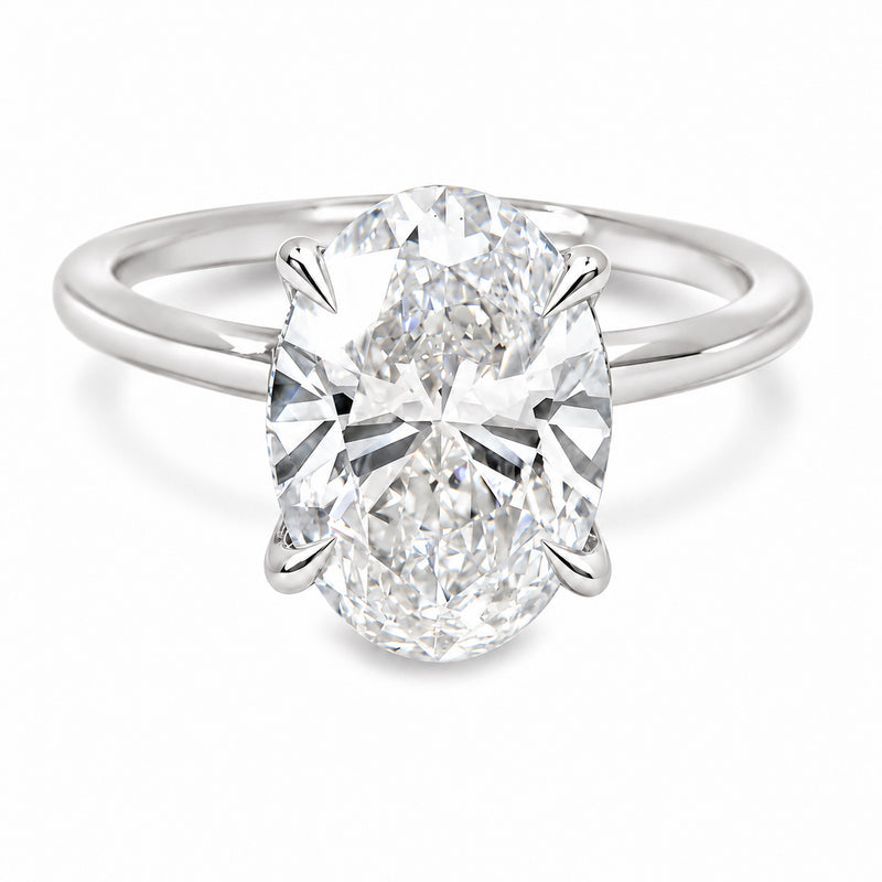 18K white gold engagement ring featuring a 5 carat oval lab grown diamond, four claw prongs, a delicate hidden halo, and a polished solitaire band