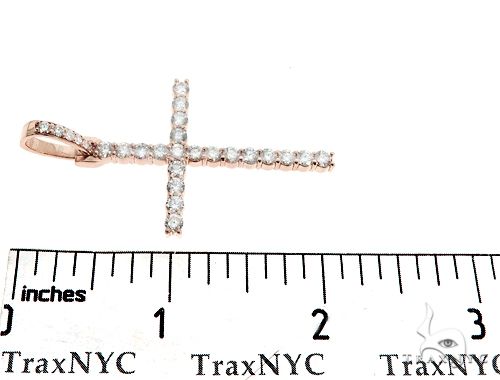 14K rose gold diamond cross pendant with prong setting, shown on ruler for size reference