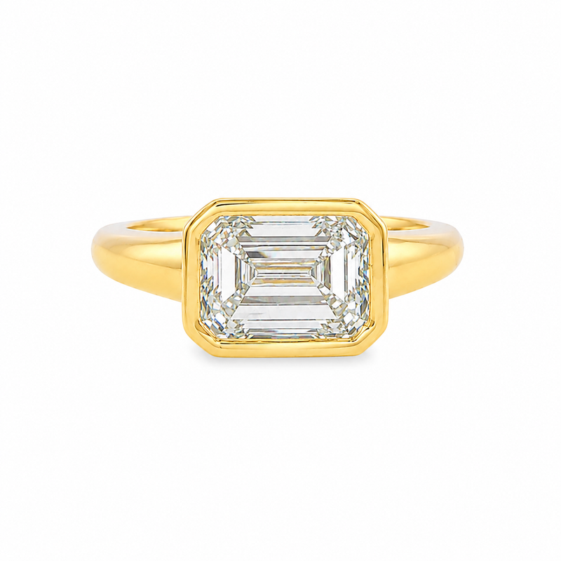 Yellow gold ring with emerald-cut diamond in a bezel setting