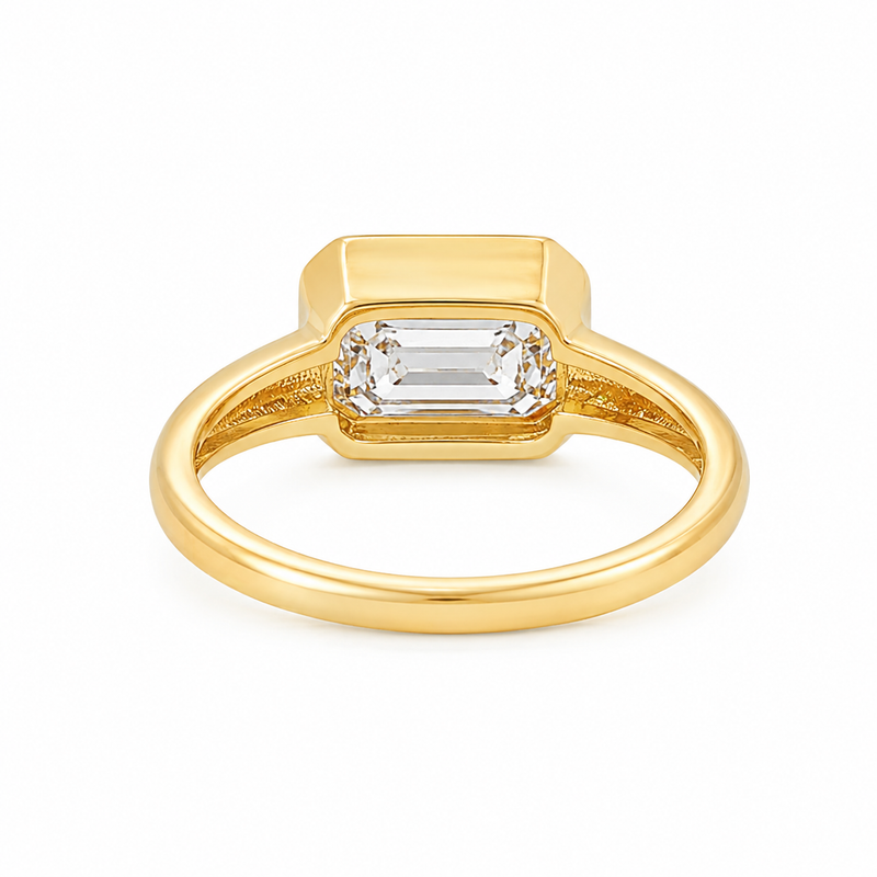 Yellow gold ring with east-west emerald-cut diamond bezel setting