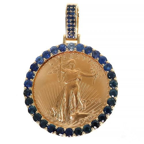 Gold pendant with blue sapphire bezel surrounding a detailed gold coin design