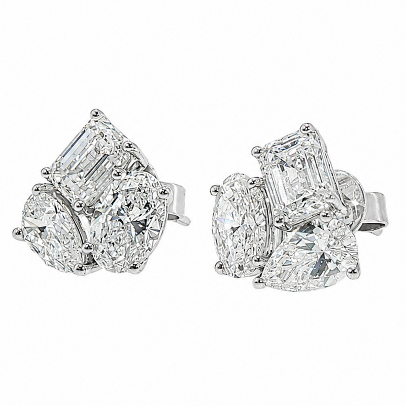 White gold cluster stud earrings with trio of emerald and pear-cut diamonds