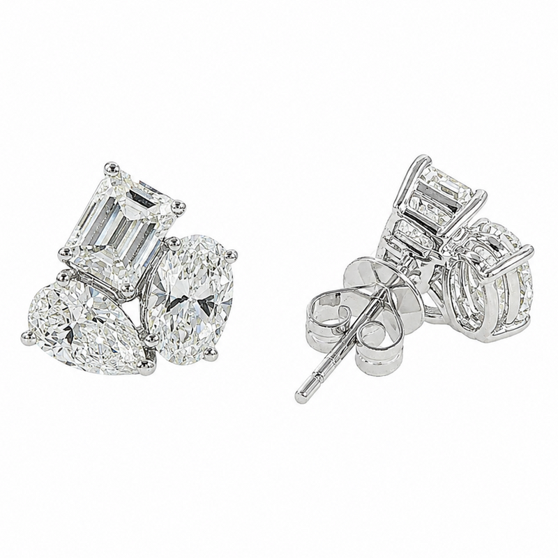 White gold stud earrings with trio of emerald, pear, and round cut diamonds in cluster design