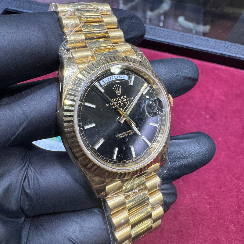 18K yellow gold Rolex Day-Date 40mm watch with black stick dial and fluted bezel