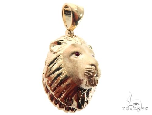 Small yellow gold lion head pendant with detailed mane and ruby red eyes