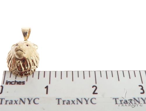 Small yellow gold lion head pendant with ruby eyes, measuring just under 1 inch tall