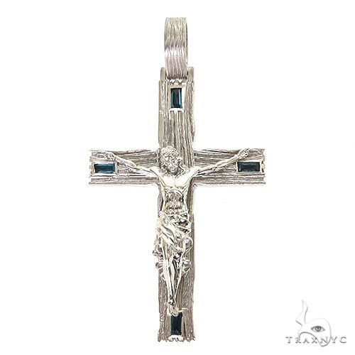 Silver cross pendant with detailed crucifix and four dark blue gemstone accents