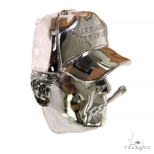 Silver pendant shaped like a man's face wearing a "Make America Great Again" hat with cigar detail