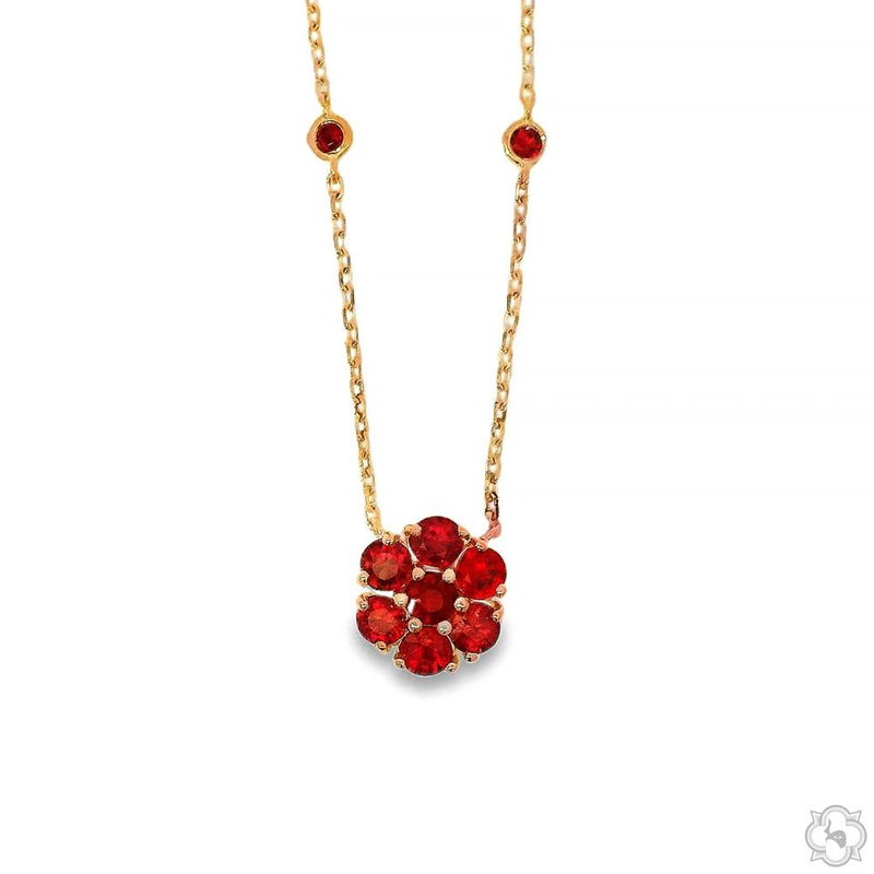 Gold chain necklace with red sapphire flower pendant and two small red sapphire accents