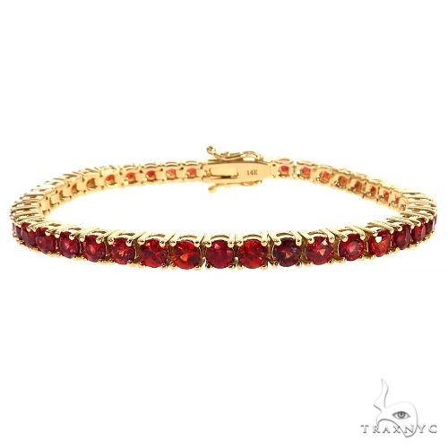 Yellow gold tennis bracelet with round red sapphire gemstones in prong settings