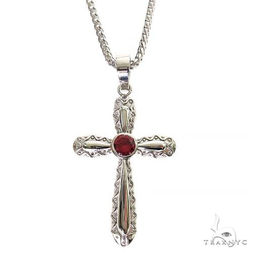 Silver cross pendant with intricate designs and round red rhodolite gemstone center on chain
