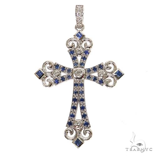 White gold cross pendant with blue sapphires and round diamonds in ornate design