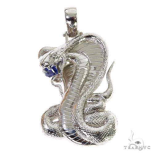 Silver cobra pendant with detailed scales and blue gemstone eyes