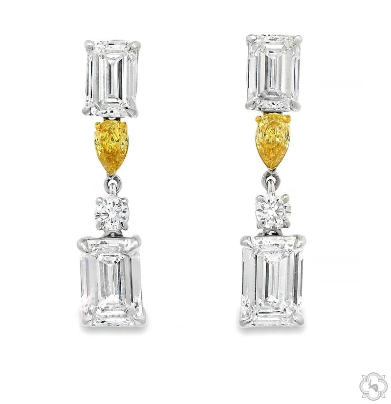 Diamond drop earrings with emerald-cut and round white diamonds and yellow pear-shaped diamond accents — front view