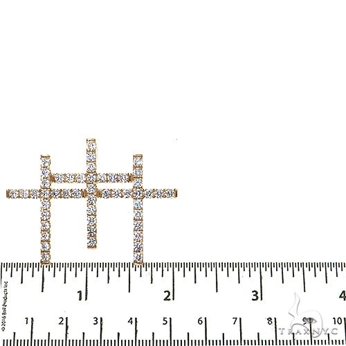 Yellow gold triple cross pendant with sparkling diamonds, shown next to measurement ruler