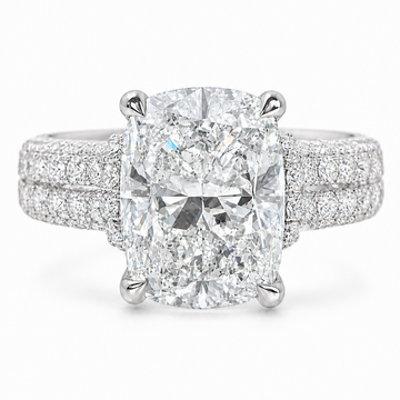White gold engagement ring with elongated cushion-cut diamond and double pavé diamond band.