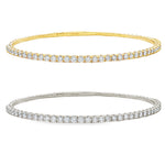 Yellow gold flexible bangle bracelet with a single row of round diamonds.