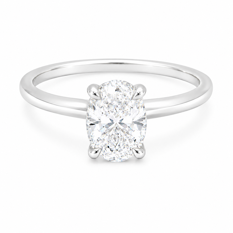 14K gold engagement ring featuring a 1.50 carat oval lab grown diamond in a four-prong setting with a hidden halo and a slim polished solitaire band.