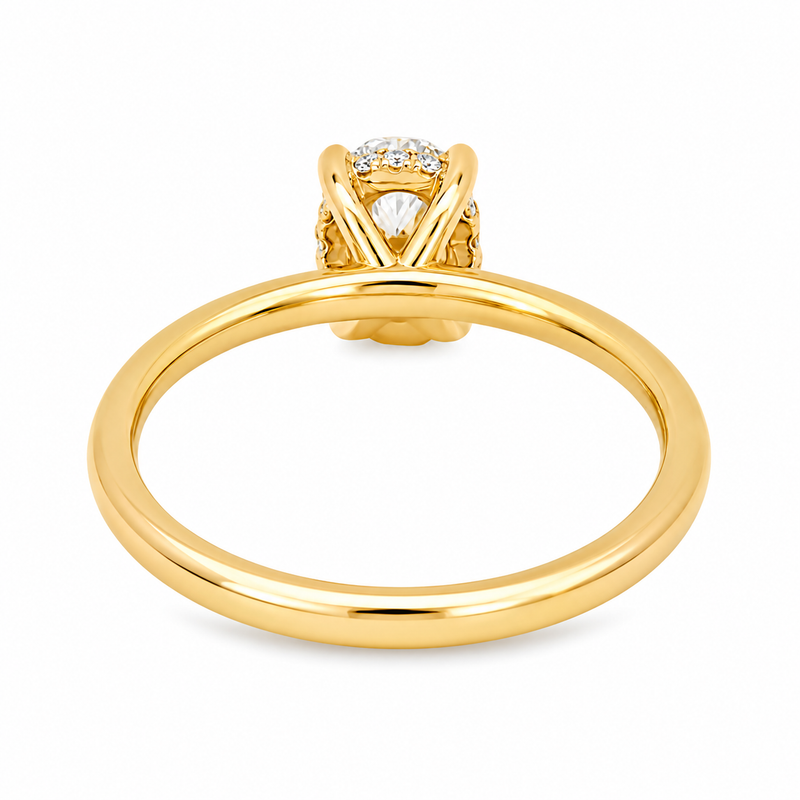 14K yellow gold engagement ring featuring a 1.50 carat oval lab grown diamond in a four-prong setting with a hidden halo and a slim polished solitaire band.