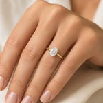 14K yellow gold engagement ring featuring a 1.50 carat oval lab grown diamond in a four-prong setting with a hidden halo and a slim polished solitaire band.
