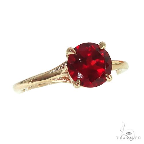 14K gold solitaire ring with round garnet center stone, angled three-quarter view