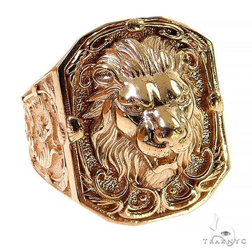 Gold lion face ring with intricate mane and ornate filigree detailing on broad band.
