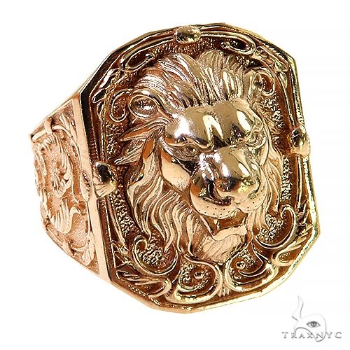 Gold lion face ring with intricate mane and ornate filigree detailing on broad band