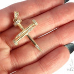 14k yellow gold cross pendant shaped like nails with diamond accents.