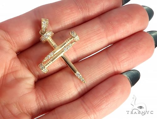14k yellow gold cross pendant shaped like nails with diamond accents.