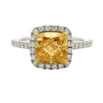Cushion-cut yellow diamond ring with halo of white diamonds on a white gold band.