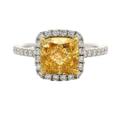 Cushion-cut yellow diamond ring with halo of white diamonds on a white gold band.