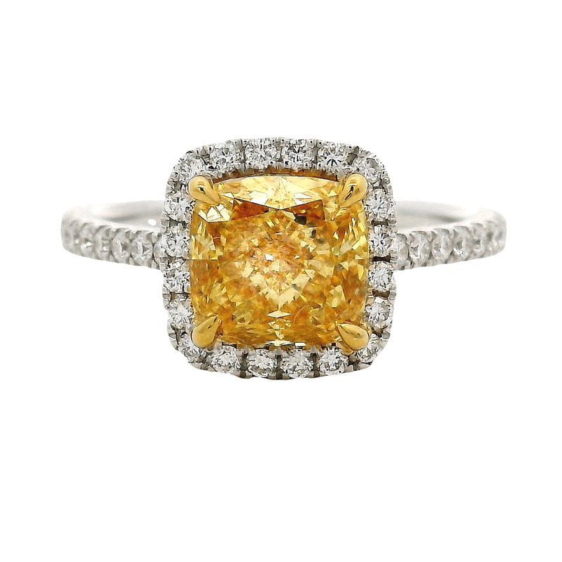 Cushion-cut yellow diamond ring with halo of white diamonds on a white gold band.