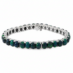 White gold tennis bracelet with oval black opal gemstones in prong settings.
