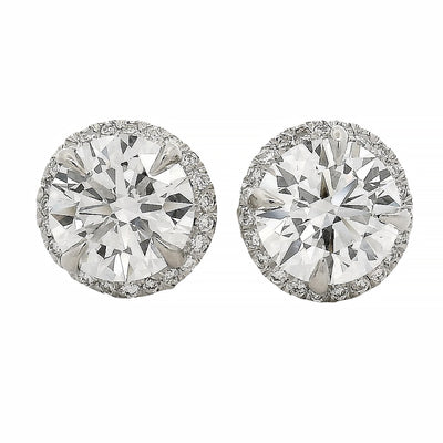 Round white gold diamond stud earrings with halo design and brilliant cut stones.