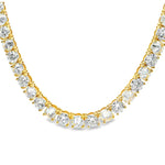 Yellow gold tennis chain with alternating upside down round diamonds.