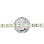Delicate opal tennis chain with round gemstones set in gold links, shown beside a quarter for size.
