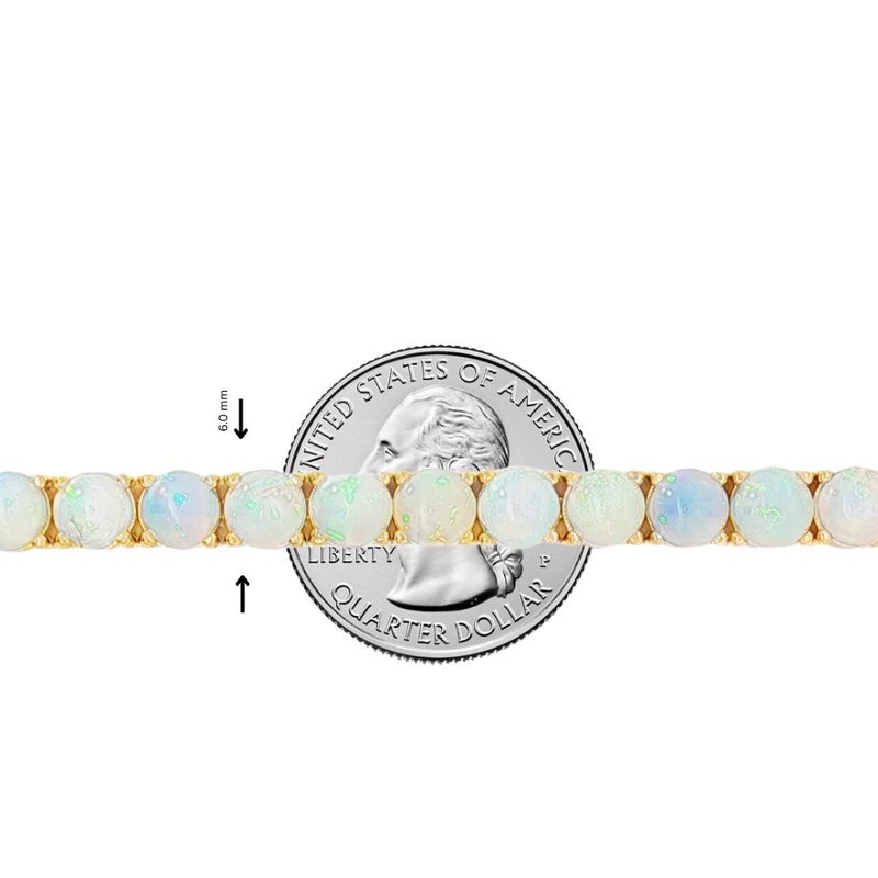 Delicate opal tennis chain with round gemstones set in gold links, shown beside a quarter for size.
