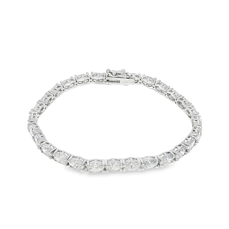 White gold tennis bracelet with oval-cut diamonds in a linked setting.