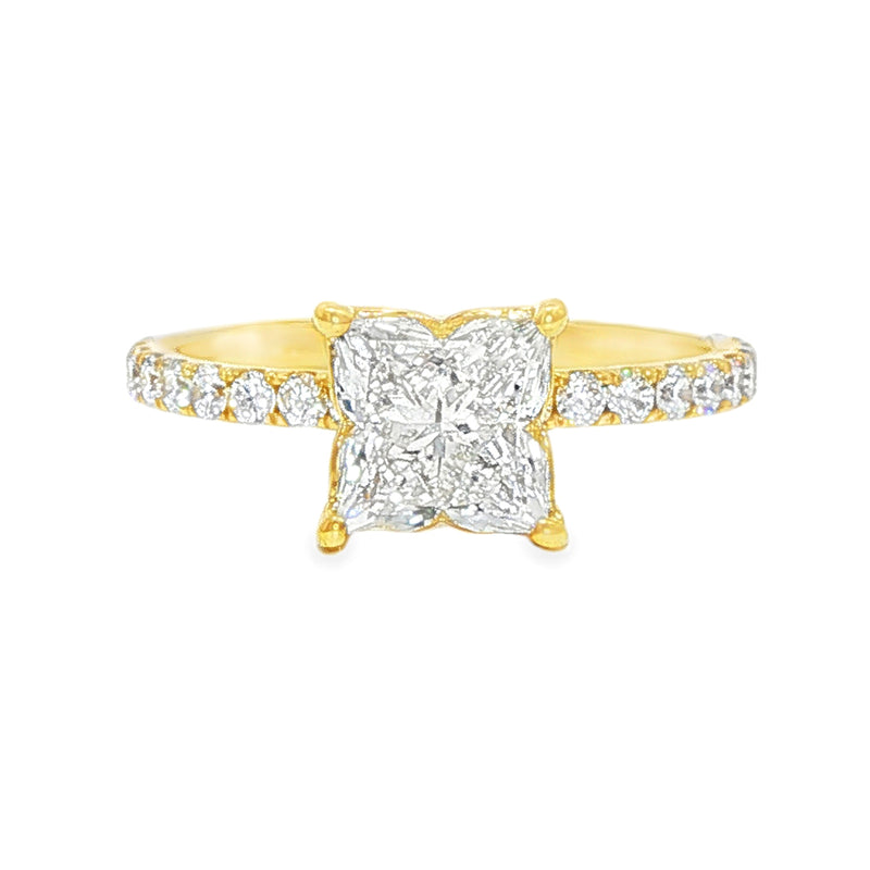 Yellow gold engagement ring with flower-shaped diamond and diamond-studded band.