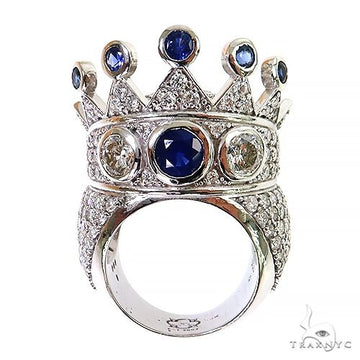 White gold crown ring with sapphire center and diamonds on band and crown points.