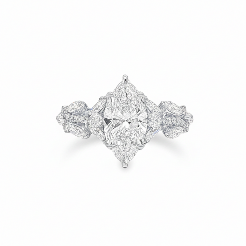 Marquise diamond engagement ring in yellow gold with intricate side diamond accents.