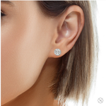 Round white gold diamond stud earrings with halo design and brilliant cut stones.