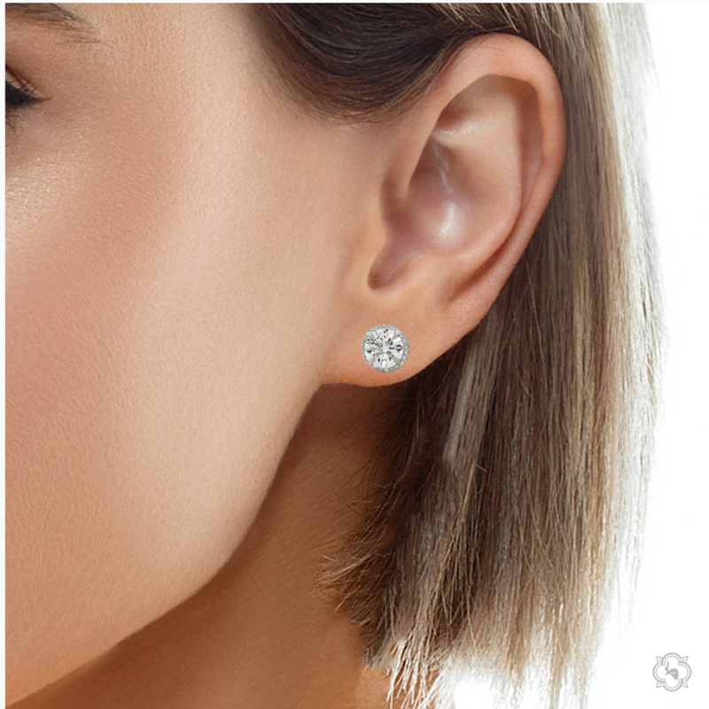 Round white gold diamond stud earrings with halo design and brilliant cut stones.