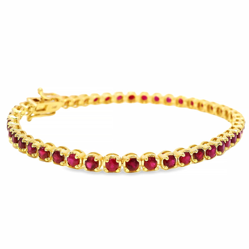 Yellow gold tennis bracelet with round ruby gemstones and secure clasp closure.